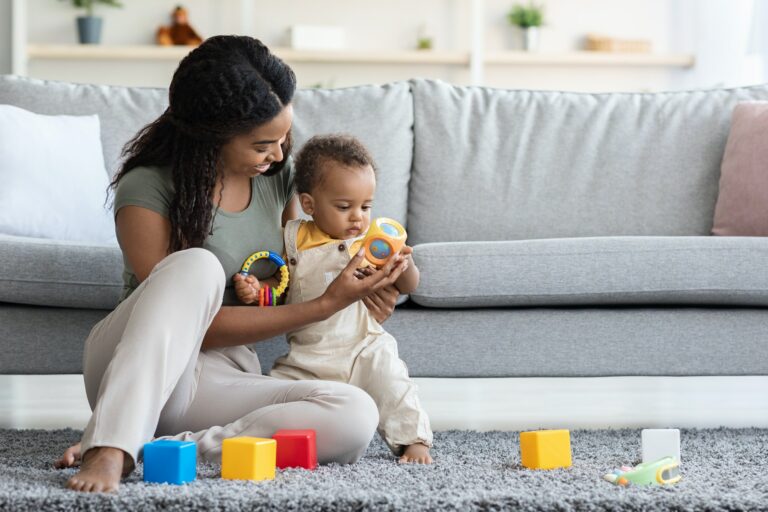 Activities With Babies. Black Mom Playing Toys With Infant Son At Home