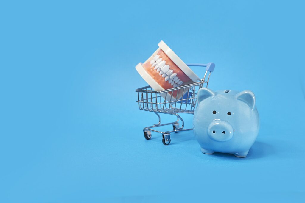 Piggy bank with White teeth model on blue background. tax offset concept.