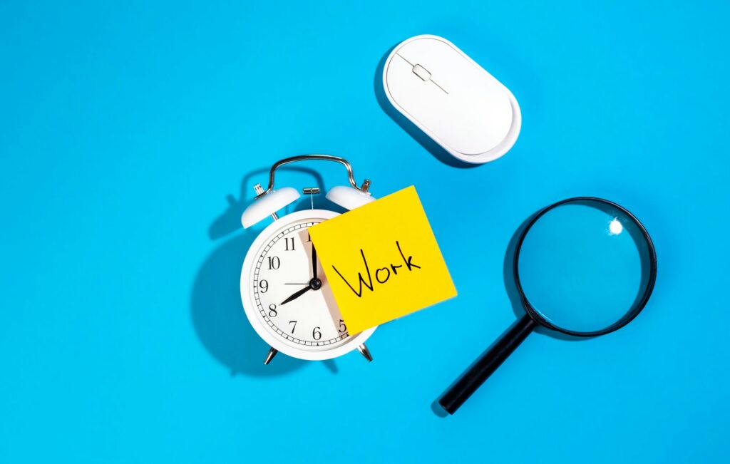 Alarm clock and a sticker with the inscription Work on a blue background.